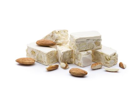 small nougat pieces with almonds, on white background.の写真素材