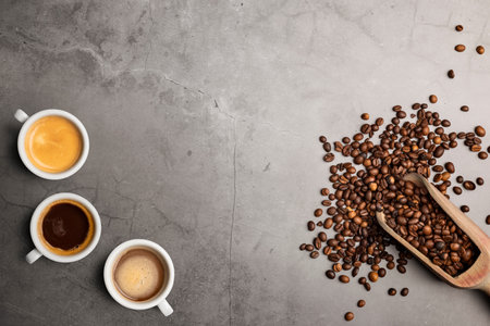 Variety of coffee cups top view with beans on stone table
