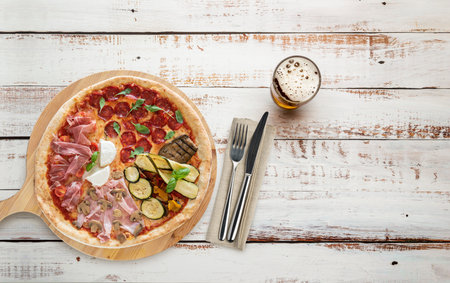 Top view of pizza on wooden cutting boards with cutlery and beerの写真素材