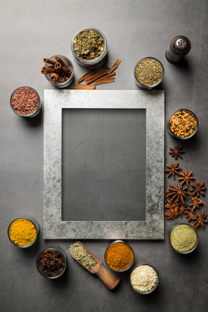 top view of glass jars with various spices on gray tableの写真素材