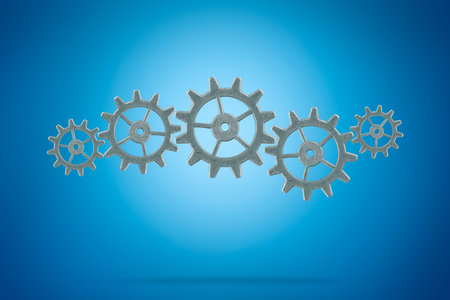Metal gears on blue background. Teamwork business concept.