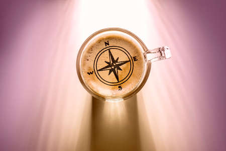 coffee cup with compass sign, top view on background with sunlight.の写真素材