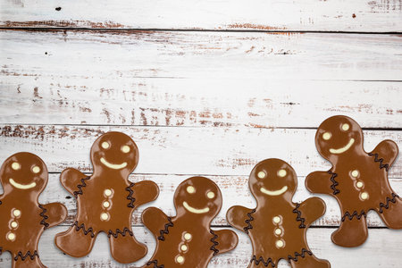 Gingerbread man cookie covered with chocolate on wooden table