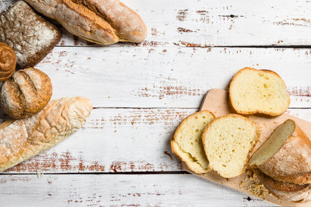 Assortment of baked bread on wooden background. Top view