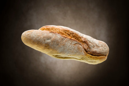 Fresh crunchy baked bread on brown background.