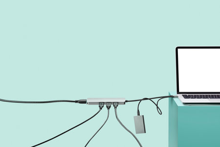 Laptop on colored pedestal with cables. blue background. Connection concept.の写真素材