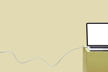 Laptop on colored pedestal with cable. Yellow background. Connection concept.の写真素材