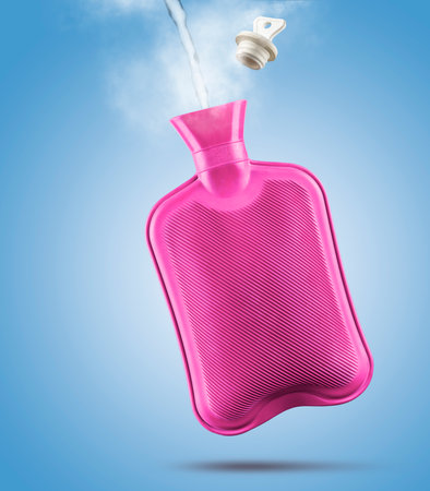 Filling hot water bottle with steam and stopper on blue background.の写真素材
