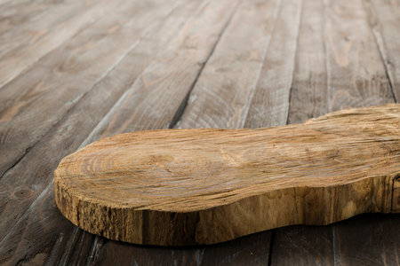 Wooden rustic cutting board on wooden table.の写真素材