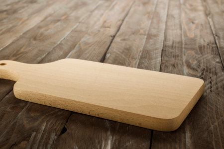 Wooden rectangular cutting board on rustic table.の写真素材