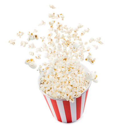 Popcorn flying from red and white striped container, isolated on white background.の写真素材