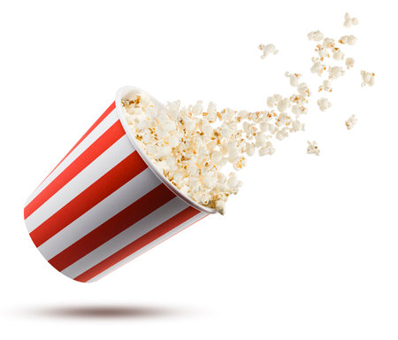 Popcorn flying from red and white striped container, isolated on white background.の写真素材