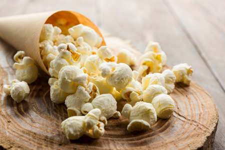 Close up of salted popcorn on wooden table.の写真素材