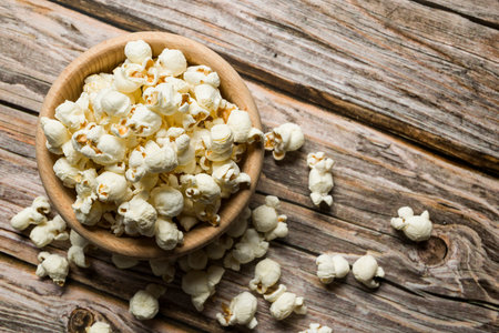 Wooden bowl with salted popcorn on wooden table. Top views.の写真素材
