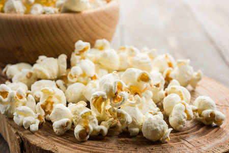Close up of salted popcorn on wooden table.の写真素材