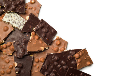 Milk and dark pieces of hazelnut chocolate on white background.の写真素材