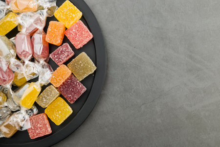assorted jelly candies on black tray, top view.の写真素材