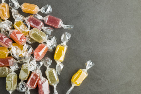 assorted wrapped up jelly candies on gray table, top view.の写真素材