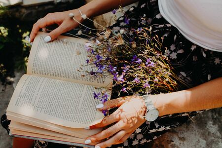 The girl in the hands holding the bookの写真素材