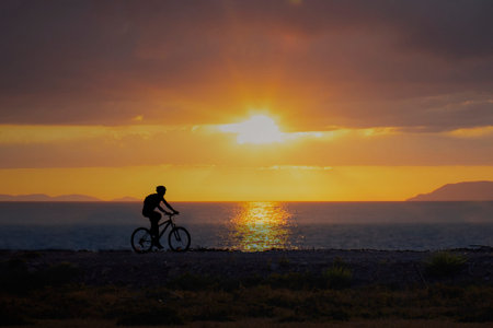 silhouette of a cyclist on the background of a sea sunset in Tuscany