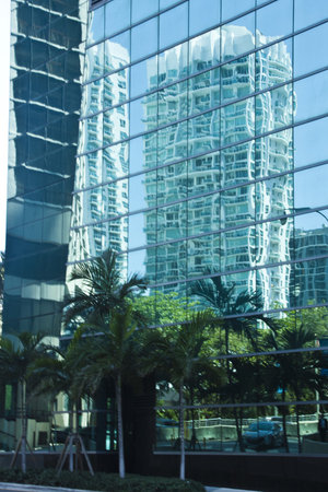 Skyscraper is reflected in the mirrored wall of another building