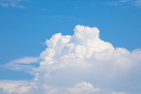 Background of blue sky with big white thick cloud. Noon, nice weather, early autumn