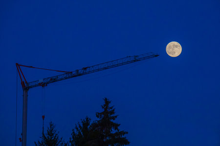 geometries of the night, large construction crane against the background of the night sky and the moonの写真素材