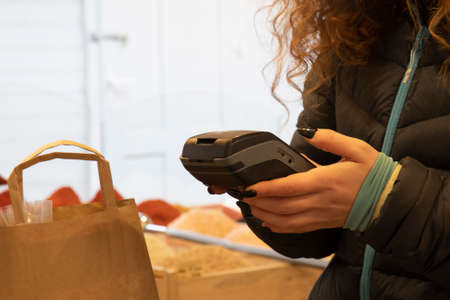 woman pays for purchases using an ATMの写真素材