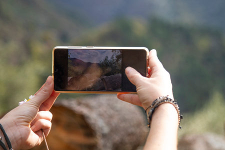 female hands take pictures with phone beautiful autumn landscape in the mountains