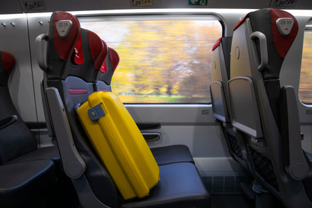 Train travel concept. Yellow suitcase on the seat in the train