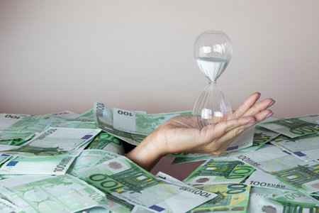 concept time is money, the hand that holds the hourglass climbs out of the pile of money