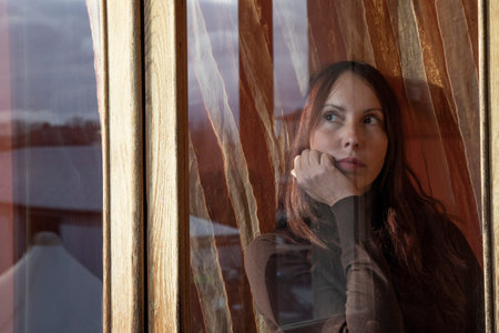 bored woman looking thoughtfully out the window