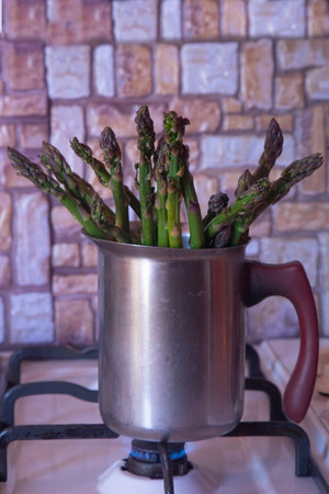 cooking asparagus in a small saucepan at homeの写真素材