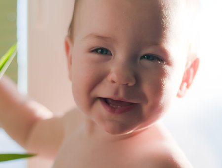 Smiling baby girl on light backgroundの写真素材