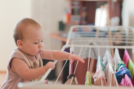 Little girl near linen taking clothesの写真素材