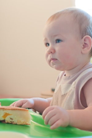 Little thoughtful  girl with cakeの写真素材