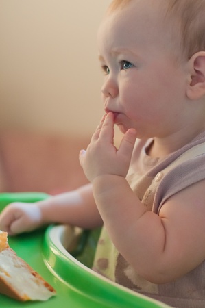 Little thoughtful  girl eats cakeの写真素材
