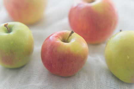Five apples lay on the white textileの写真素材