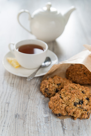 Tea with the oatmeal cookies in the paper bagの写真素材