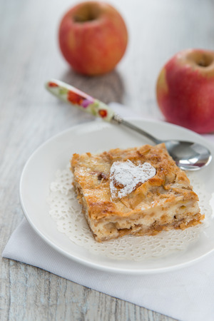 Piece of an apple pie and two applesの写真素材