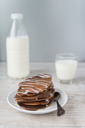 Chocolate pancakes with the glass and bottle of milkの写真素材