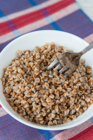 Plate of the buckwheat cereals on the coloured napkinの写真素材