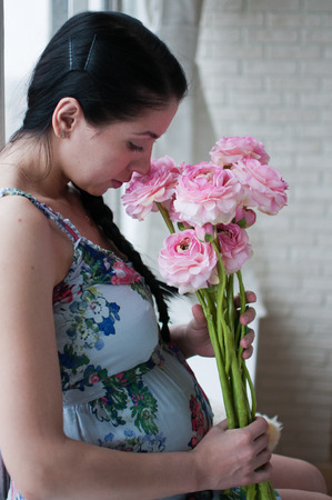 Portrait of the pregnant woman with flowersの写真素材