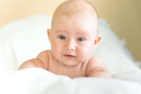 Little baby laying on the white blanketの写真素材