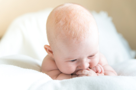 Little baby laying on the white blanketの写真素材