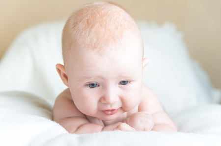 Little baby laying on the white blanketの写真素材