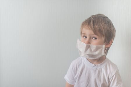Little boy in medical mask looks in the cameraの写真素材