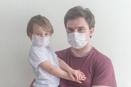 Man holds little boy and they are weared in medical masksの写真素材