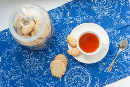Cup of tea with cookies on the blue textileの写真素材