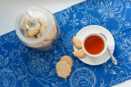 Cup of tea with cookies on the blue textileの写真素材